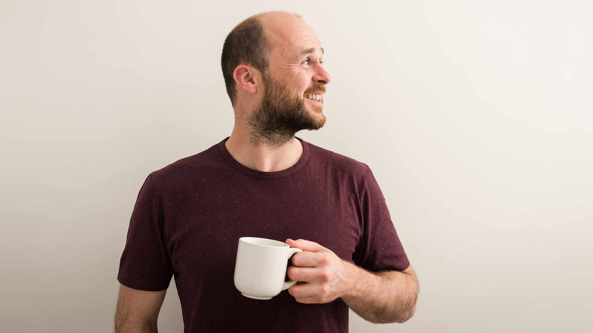 Martin Underhill of tempertemper Web Design, holding a cup of tea and looking to his left, smiling.